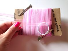 a person holding scissors and some pink fabric