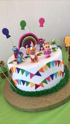 a birthday cake decorated with cartoon characters and balloons