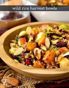 a wooden bowl filled with fruit and nuts