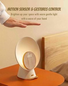 the motion sensor and gestures control is on top of a table with an alarm clock