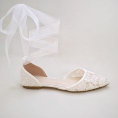 a pair of white shoes with a ribbon tied around them