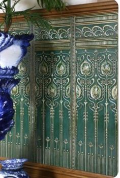 two blue vases sitting on top of a wooden table next to a green wall