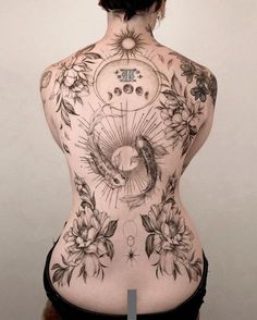 the back of a woman's body with tattoos on it