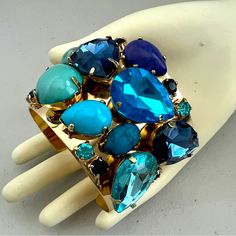 Multi Rhinestone & Gold Tone Cuff Nwt Large Rhinestones & Other Stones In Shades Of Oceanicblue Bright Gold Tone Metal Cuff Metal Stretches Slightly For Easy Wear And Molds To The Wrist Stunning Cuff Blue Jeweled Bracelet As Gift, Blue Jeweled Bracelets Perfect For Gifts, Blue Jeweled Bracelet For Gift, Blue Jeweled Bangle Jewelry, Blue Bangle Cuff Bracelet For Party, Adjustable Blue Cuff Bracelet For Party, Blue Jeweled Bracelets For Wedding, Blue Jeweled Wedding Bracelets, Blue Jeweled Bracelets For Party