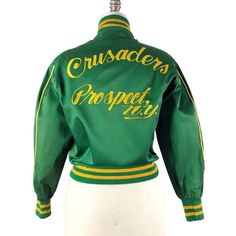 a green and yellow jacket with the words crusaders project on it's chest