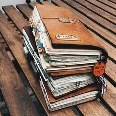 a stack of books sitting on top of a wooden bench