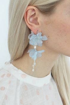 a woman with blonde hair wearing blue earrings