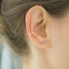 a close up of a person's ear with a single diamond in the middle