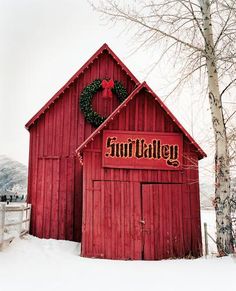 a red barn with a wreath on the door and sign that says fruit valley in front of it