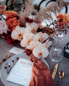 an elegant table setting with flowers and menu