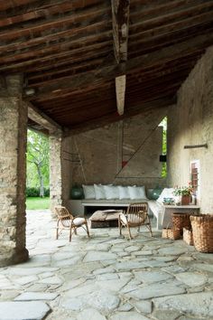 an outdoor living area with stone flooring and furniture