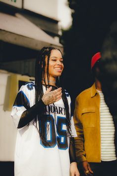 a woman with dreadlocks standing next to a man