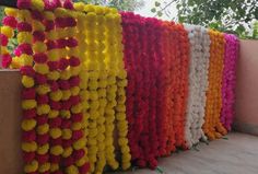 many different colored pom poms are lined up on the side of a building