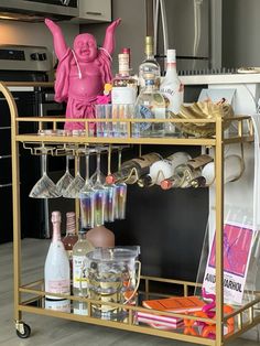 a gold bar cart filled with bottles and glasses