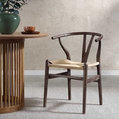 a wooden chair next to a table with a potted plant on it