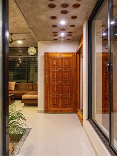 an entry way leading to a living room with a clock on the wall and potted plant