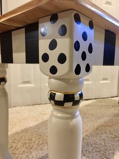 a table with black and white polka dots on it, sitting in the middle of a carpeted room