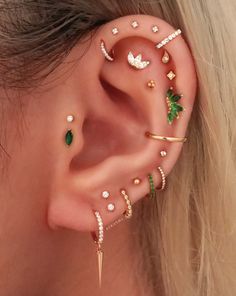 a woman's ear with several piercings on it