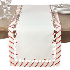 a table runner with red and white trimmings on top of a wooden table