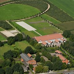 an aerial view of a large farm with lots of trees and grass in the foreground