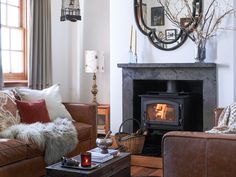 a living room filled with furniture and a fire place in front of a mirror on the wall