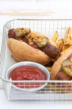 two hot dogs and fries in a basket with ketchup