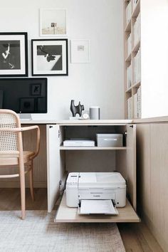 a white printer sitting on top of a wooden shelf in front of a computer desk