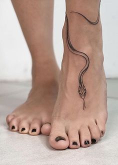 a woman's foot with a snake tattoo on it