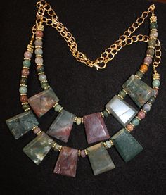 This is a definite 'Statement' necklace--it has all the components needed to make this a 'One-of-A-Kind'.  The main focal point of this necklace is the 5  Faceted Trapezoid India Agate--each piece makes a statement all by themselves but when you place them all together, they make a visually striking 'STATEMENT' to convey a particular image of this piece of jewelry.  The necklace also includes gold accent pieces--spacer beads and gold chain; and other matching India Agate and Fancy Jasper stone beads to further enhance the beauty of this necklace. Earrings are included in the price and you may choose to change the ear wire fishhooks (current setting); posts; or leverbacks at no extra charge. India Agate Stones are defined as 'semi-precious' gems.  India agate comes in a wide range of colors Fancy Jasper, Stone Necklace Set, Semi Precious Gems, Green Agate, Agate Necklace, Jasper Stone, Gold Accent, Precious Gems, Agate Stone