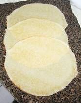 three uncooked tortillas sitting on top of a counter