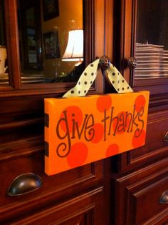 a sign that says give thanks hanging on a dresser