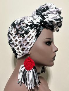 a mannequin head wearing a knitted hat with tassels