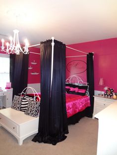 a pink and black bedroom with four poster bed