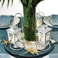 a vase filled with flowers sitting on top of a table next to plates and napkins