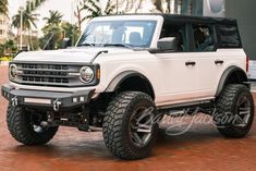 a white truck parked on top of a brick road