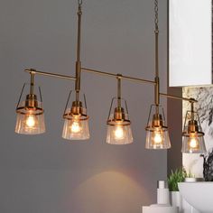 a light fixture with five lights hanging from it's sides in a kitchen or dining room