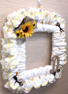 a wreath made out of diapers with a sunflower on it and the letter q