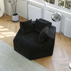 a black chair sitting on top of a hard wood floor next to a radiator