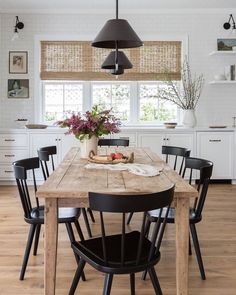 a dining room table with black chairs around it