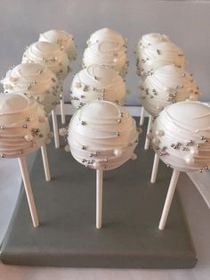 there are many white cake pops with pearls on them