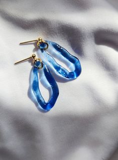 Gorgeous glass earrings in beautiful blue color.  Earrings catch the light beautifully. Perfect for adding an unexpected pop of colour to your everyday essentials. Earrings are made from hard and durable borosilicate glass.  My jewellery is created to strengthen your natural beauty and power. Perfect for sensitive ears because of their lightness and combination with surgical steel (silver or gold) earrings parts. Each piece is handmade in the lampworking techinque, which gives it a unique character, therefore each piece can be a little bit different. And this is the biggest value of my products, to make you feel special. All the products are packed safely in the beautiful paper box and will be a perfect gift for yourself or your special one. Length of glass elements: 3 cm Earstuds: surgica Glass Earrings Handmade, Glass Hoop Earrings, Blue Glass Earrings, Handmade Light Blue Glass Jewelry, Cheap Blue Glass Earrings, Water Earrings, Mermaid Look, Artsy Blue Resin Earrings, Blue Flower-shaped Glass Jewelry