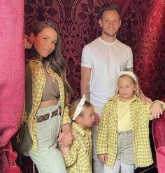 a family posing for a photo in front of a pink curtain