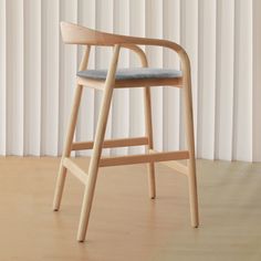 a wooden chair sitting on top of a hard wood floor next to a white wall