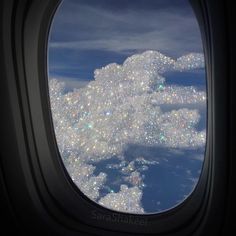 an airplane window looking out at the clouds