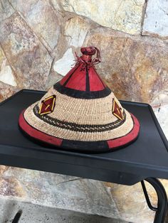 This beautiful woven hat is made by talented craftsmen living in Accra and it's surrounding villages. It's made using dried grass and leather popularly called Fulani hat. MEASUREMENTS Diameter: 14 inches Wide Height: 10 inches USES This hat is ideal to compliment your fashion sense and also, to prevent direct sunlight from burning your head. Brown Woven Straw Hat Artisan Style, Brown Artisan Toquilla Straw Hat, Handmade Red Straw Hat With Curved Brim, Artisan Handwoven Brown Hat, Artisan Brown Handwoven Hat, Traditional Natural Straw Hat, Traditional Brown Straw Hat With Curved Brim, Handwoven Straw Hats In Brown, Brown Straw Hat Handwoven