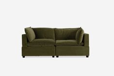 a green couch sitting on top of a white wall