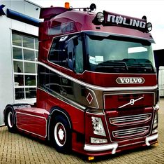 a red volvo truck parked in front of a building