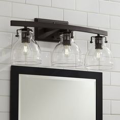 a bathroom vanity with three lights and a mirror