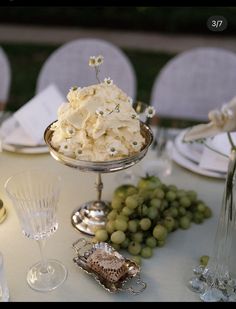 the table is set with grapes, silverware and other items for an elegant wedding reception