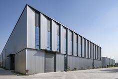 an industrial building with many windows on the front and side walls that are made of metal